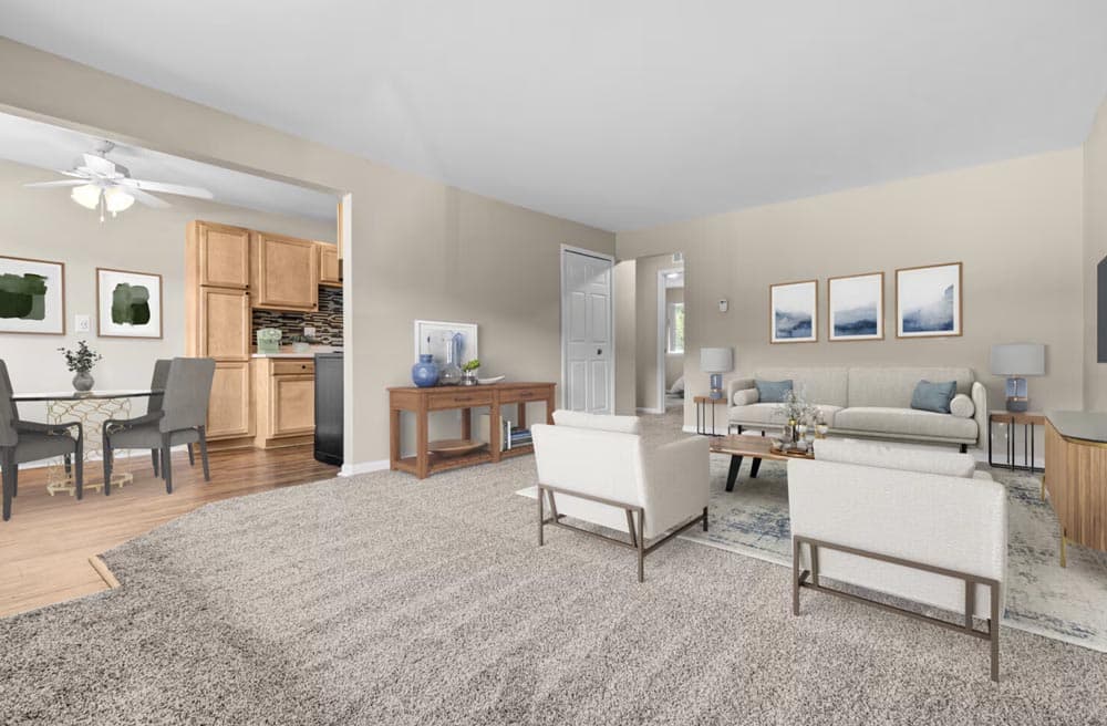 Spacious living room with beige walls, modern furniture, and a view into the kitchen and dining area.