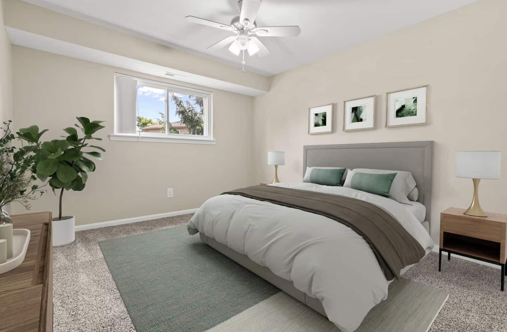 Modern bedroom with beige walls, a large bed, bedside lamps, and a plant near the window.